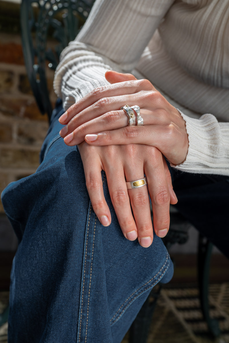Crossed hands wearing stacked Joon silver and gold handmade rings